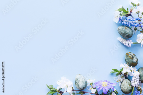 Easter flat lay. Stylish easter eggs and cherry flowers on blue background. Easter celebration, season greetings mockup. Spring modern floral banner