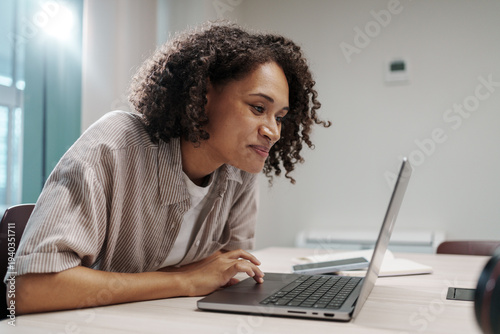 Dedicated Female Worker Reviewing Spreadsheet Details While Sitting In Quiet Modern Workspace