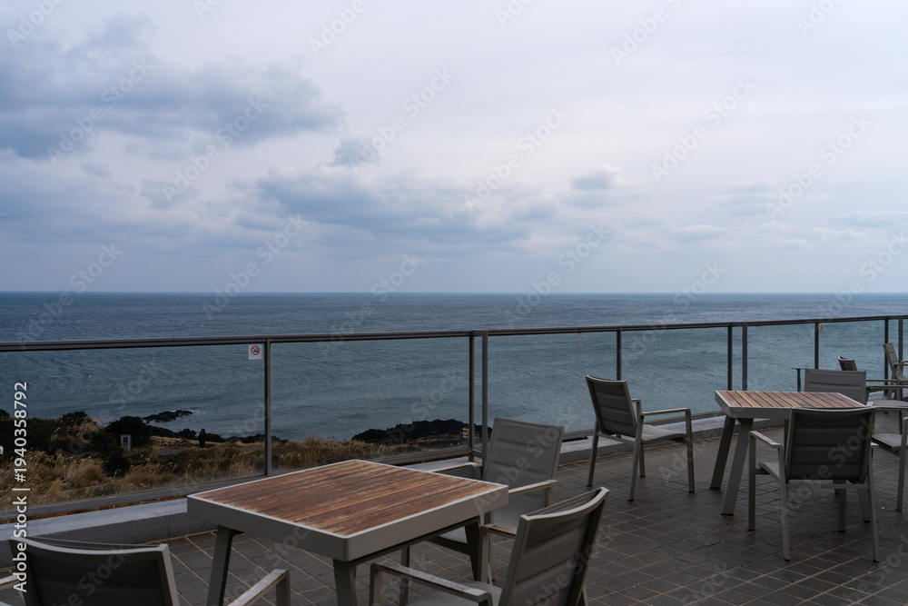 Fototapeta premium outdoor cafe and overcast seascape at Seopjikoji in Jeju Island, South Korea