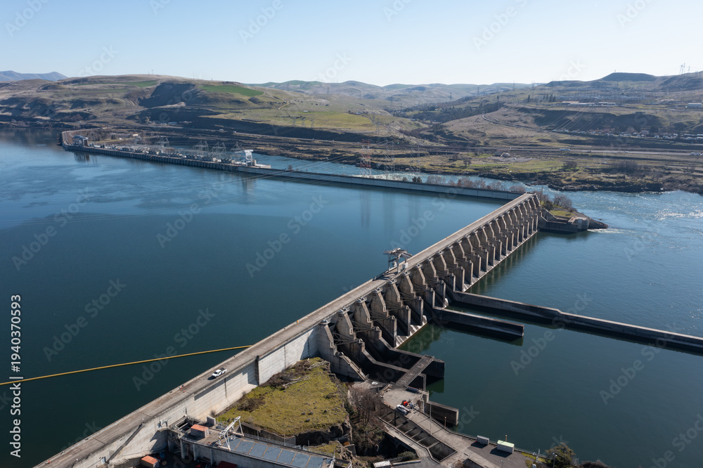 Obraz premium Aerial drone footage of The Dalles Dam hydroelectric facility on the Columbia River in The Dalles, Oregon, USA generating renewable energy and supplying electricity to the regional power grid