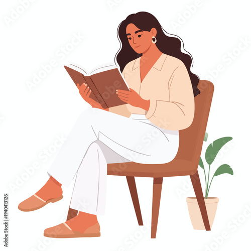 A woman sits on a chair reading a book indoors with a plant nearby.
