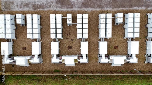 Top-down aerial drone view of a large-scale Battery Energy Storage System (BESS) in Burwell, UK, featuring modular lithium-ion battery containers.