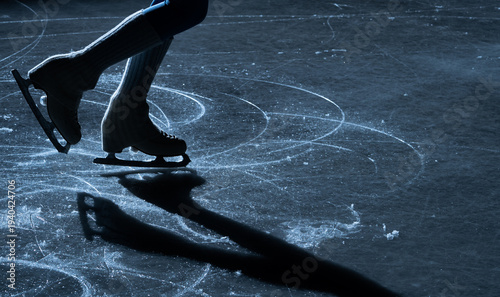 Cuadro en lienzo Close up of figure skater legs and blades on a shiny indoor ice rink with reflection and shadow