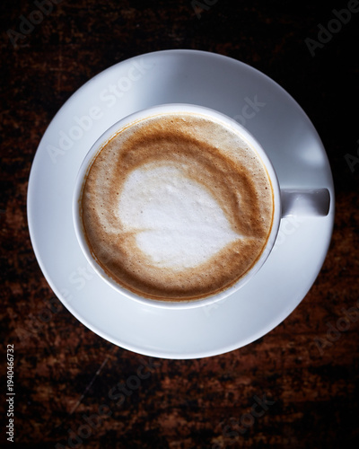 Cappuccino Coffee with Frothy Milk Foam in White Cup on Dark Wooden Table Top View