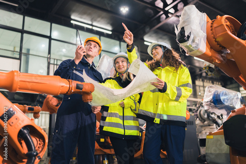 Engineers planning automation project in modern factory. Team discussing robotic arm integration, industrial development, future technology, smart manufacturing. Engineering, industry, technology