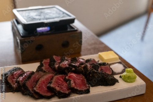 Set of Black Gyukatsu or beef cutlet served with butter. A traditional Japanese food that consists of a deep-fried beef cutlet.