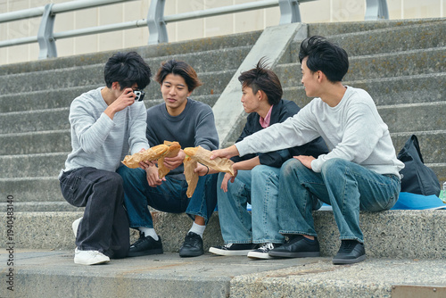 Photos 屋外で一緒に食事をする若い男性たち