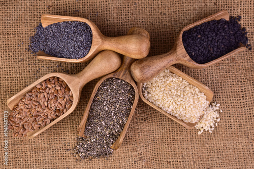 Healthy seeds - sesame, flaxseed, chia seeds, hemp seed and black sesame seed in wooden spoons. View from above