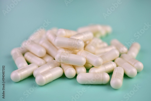 Close-up of many vitamin C capsules on a green background.
