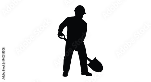 Worker with shovel stands in a dark striking silhouette