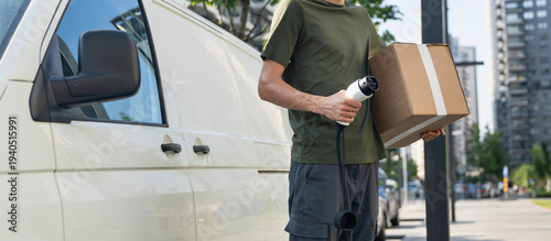 Driver with charging plug next to of electric van