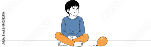 A thoughtful young boy sits calmly on the floor next to a deflated orange balloon, lost in quiet contemplation, evoking a sense of childhood reflection and simplicity in a serene setting
