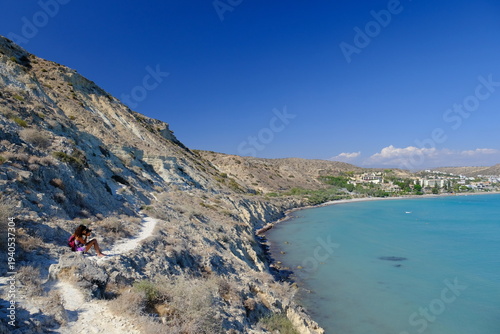 Female traveler photographing scenic cliffs at Cape Aspro Pissouri, Cyprus	