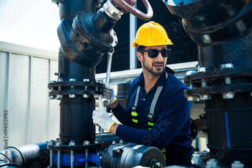 Quadro em tela Industrial engineer operating large pipeline valve during cooling tower maintena