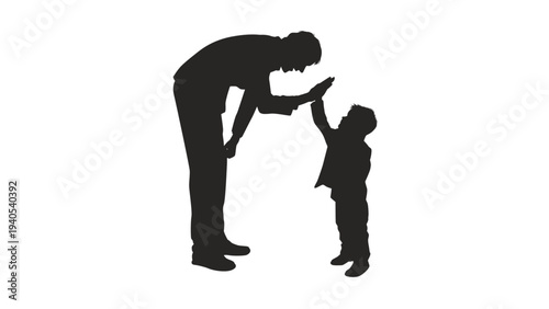 Silhouette of father and little son doing high five gesture.