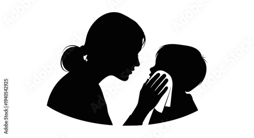 Mother gently wiping child's face with a cloth in silhouette.
