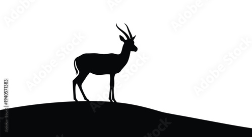 Antelope stands on a hill dramatically presented as a silhouette