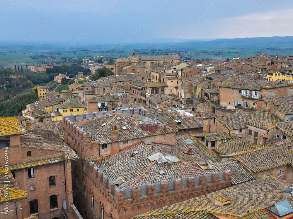 Naklejka premium High angle panoramic view of Siena historic center with traditional terracotta rooftops and the Tuscan countryside, Italy