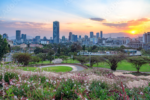 Sunset view of Addis Ababa with  a serene blend of lush greenery, flowering gardens, and a striking modern skyline.