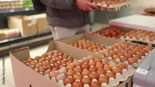 The eggs in the egg tray are neatly arranged and sold in supermarkets in malls. Man buying fresh eggs in supermarket.