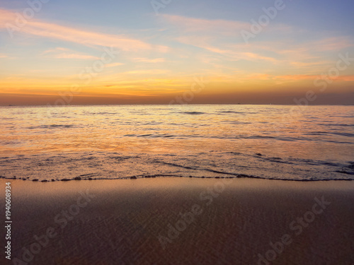 The sun has set behind the horizon, the sky is in warm shades, the sea is calm, with slight ripples on the surface, Andaman Sea, Phuket