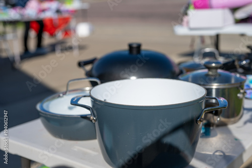 Row of second-hand pots and pans at a garage sale