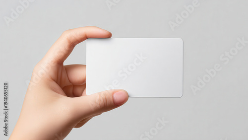 A hand holds a blank white card, ready for customization with branding, text, or a unique design.