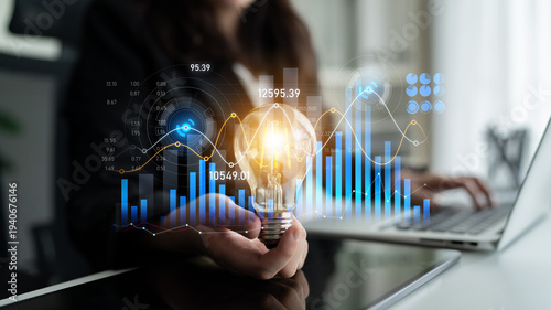 Canvas Print A business professional showcases a light bulb representing innovation alongside data analytics, graphs, and charts, highlighting growth and strategic thinking in a modern workspace