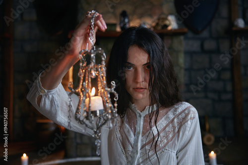 Mysterious woman with damp hair conducts occult ceremony amidst medieval stone walls