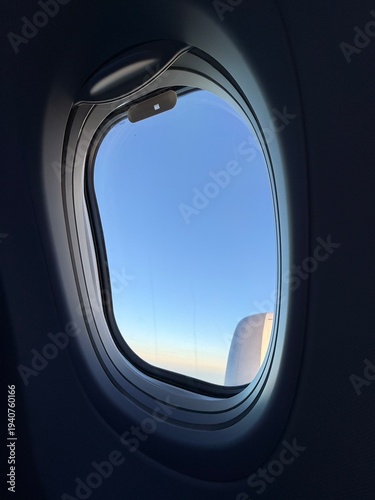 View from an airplane window during sunset, warm golden light reflecting on the aircraft wing, dramatic clouds and colorful sky, high-resolution travel photography.