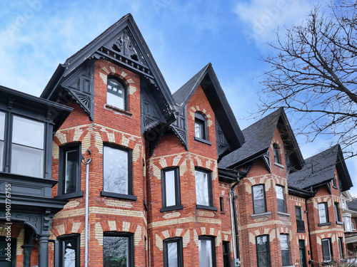 Row of narrow Victorian brick houses with gables
