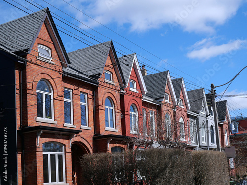 Row of narrow Victorian brick houses with gables