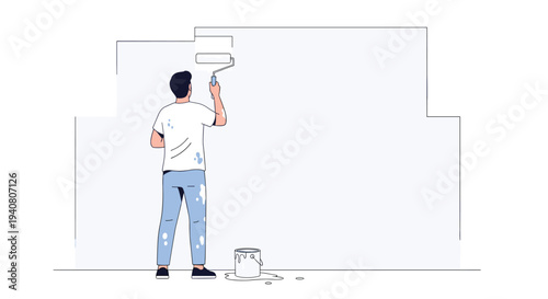 A man is seen from behind, diligently painting a large white wall section with a roller, with paint splatters on his attire.