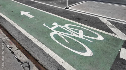 E-bike with child on back rides diagonally through shot of green bike lane