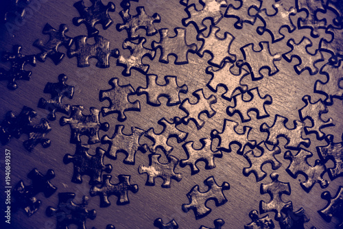 Scattered puzzle pieces with soft lighting creating a conceptual scene ideal for psychology, mind processes, problem solving, strategy, cognition, creativity, teamwork, challenge and abstract ideas.