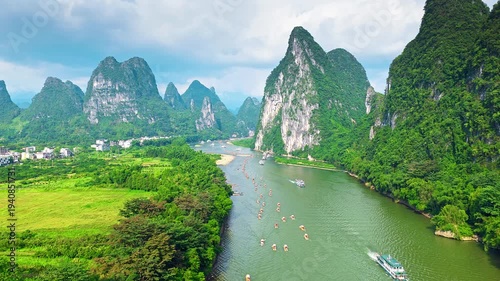 Breathtaking aerial view of the Li River winding through limestone karst mountains in Guilin, China, featuring traditional bamboo rafts and lush tropical landscape.