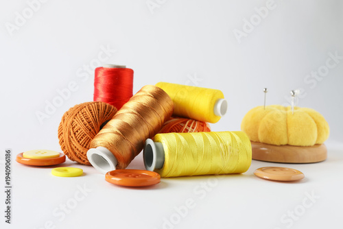 Many different sewing supplies on light grey background, closeup