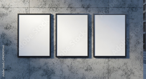 Three blank white frames with black borders on a textured concrete wall, ready for art or display.