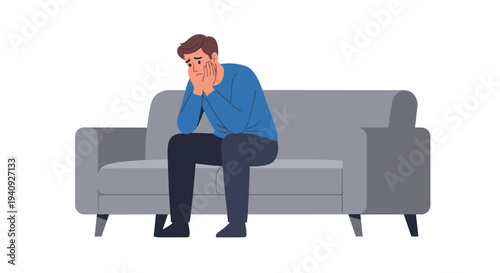 A distressed man in a blue shirt sits slumped on a grey sofa, holding his head in his hands against a white background.