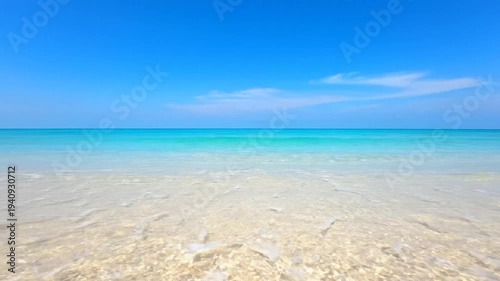 Serene Tropical Beach with Crystal Clear Turquoise Water and White Sand Under Blue Sky