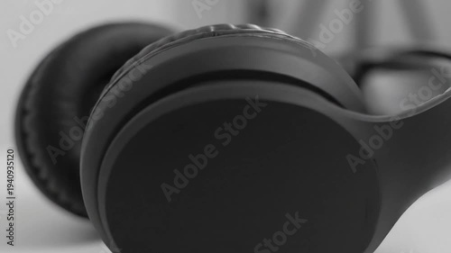 Black over-ear headphones resting on a white table with a blurred background