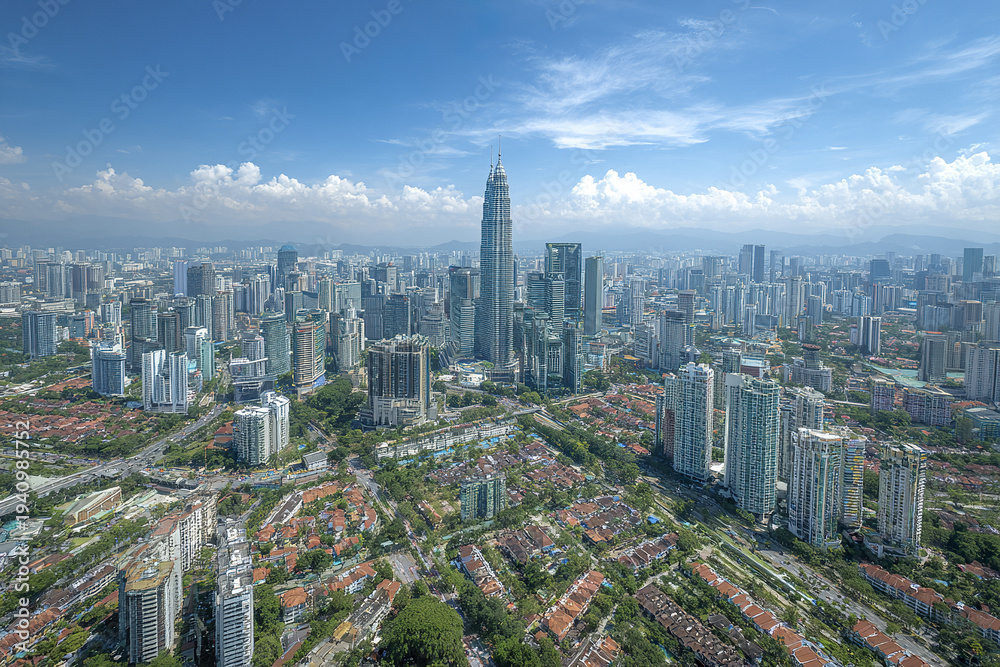 Fototapeta premium Aerial wide shot of city skyline with skyscraper towers and residential buildings under blue sky with clouds, showing urban landscape and modern architecture in daylight