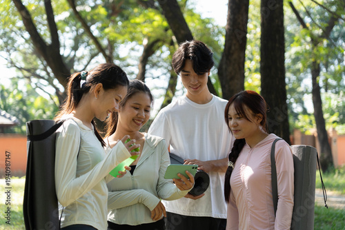 Group of yoga class watching yoga video on smartphone