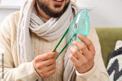 Ill young man with nebulize...