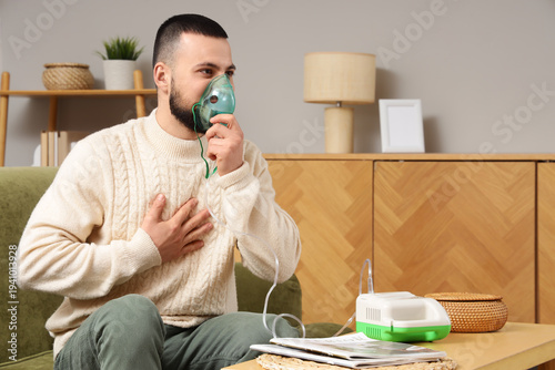 Young man using nebulizer o...