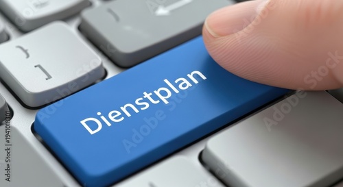 Finger Pressing Blue Dienstplan Button on Keyboard for German Shift Schedule and Roster Concept