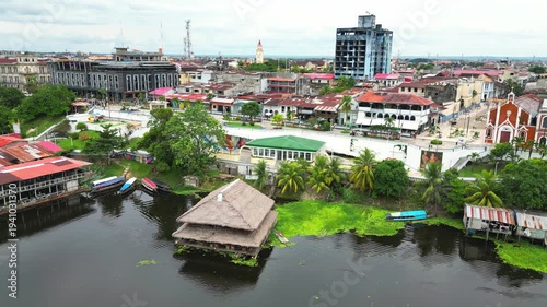 High-resolution aerial view of the riverfront boulevard in Iquitos featuring colorful historic buildings, vibrant urban streets, and a scenic promenade along the majestic Amazon River