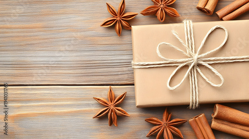 Beautifully wrapped gift with star anise and cinnamon on wooden table