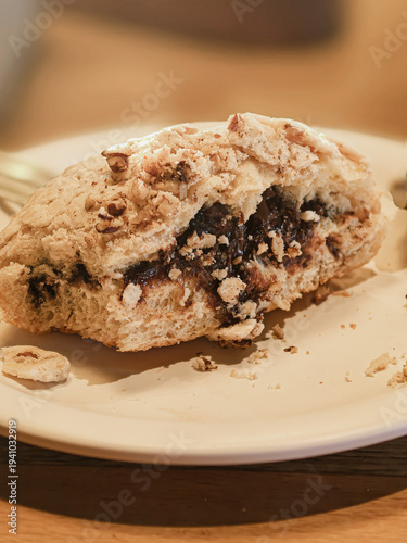 Mexican sweet bread Concha sliced in half and filled with hazelnut chocolate cream on dark background