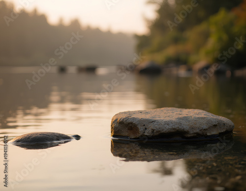 Sunset over calm river with smooth stones Soft light reflects on water surface for product display